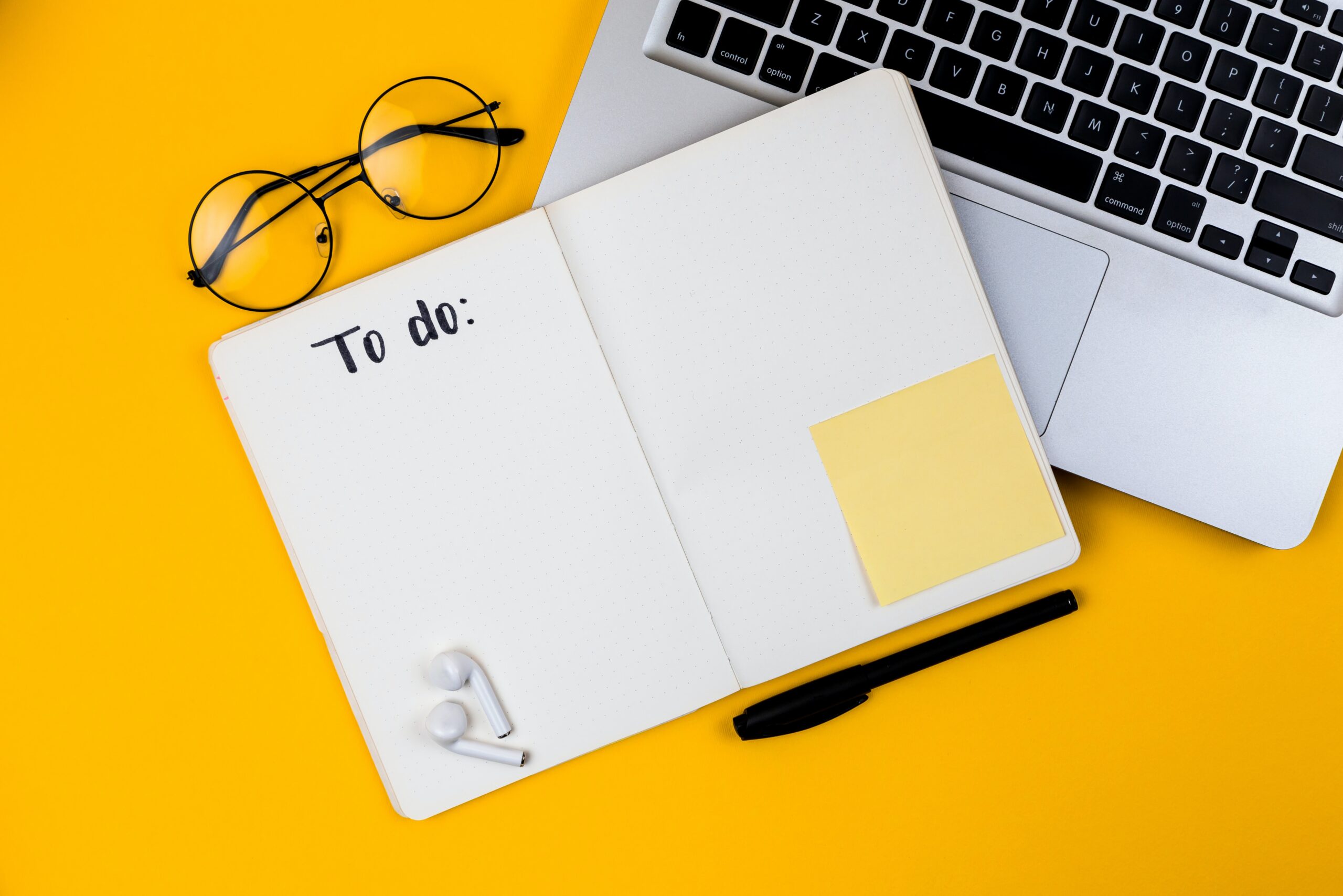 An image of a to-do list and a computer with a yellow background