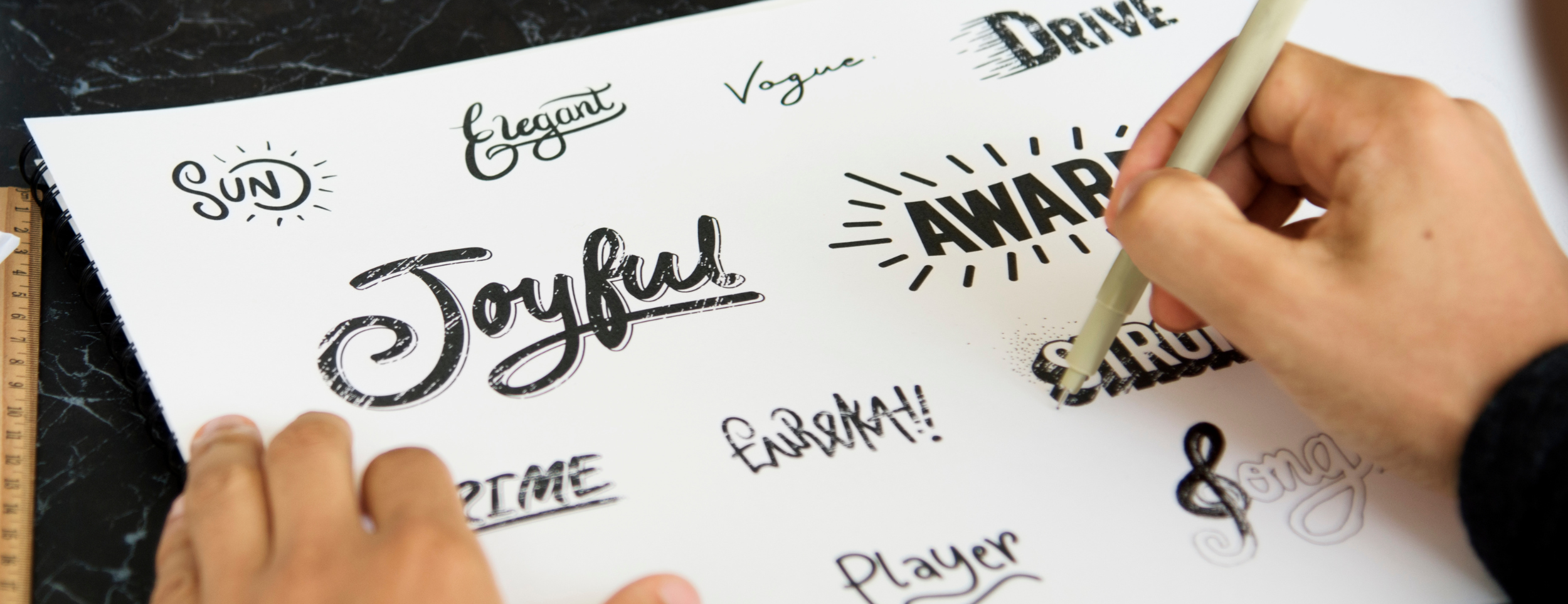 image of a person writing in different fonts or scripts